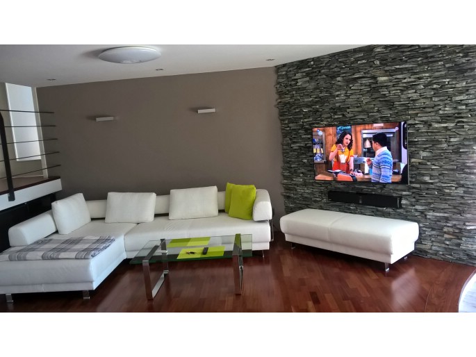 Prodej TV přijímače s montáží na zeď včetně ozvučení interiéru. [Montáž TV na zeď s ozvučením obývacího pokoje.]